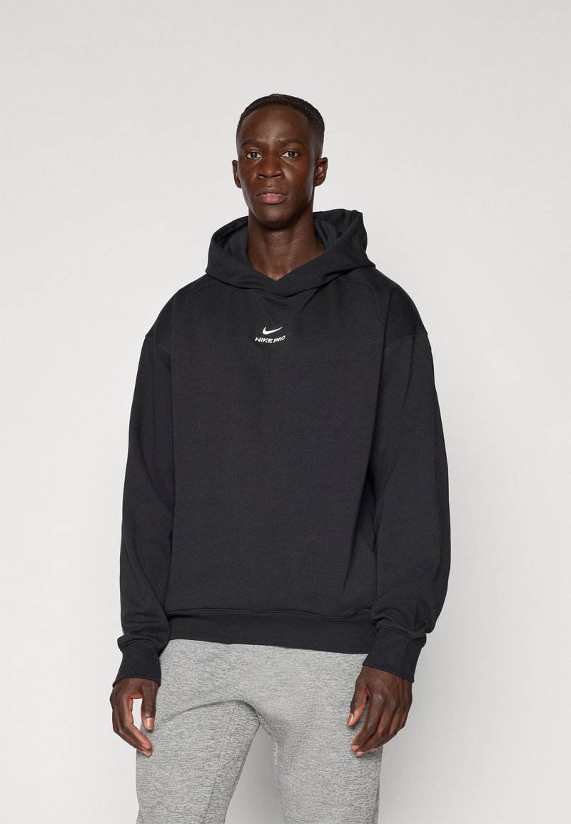 Černá mikina Nike Pro s logem na přední straně, dlouhými rukávy a kapucí se stahovací šňůrkou. Měkká tkanina s volným střihem a žebrovanými manžetami.
