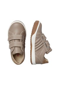 Chaussures en similicuir beige avec deux straps Velcro, des coutures blanches et des semelles en caoutchouc beige clair, présentant un design texturé sur le côté.