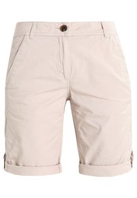 Shorts en coton beige clair avec fermeture à bouton, poches avant et revers retroussés. Texture lisse et design décontracté.