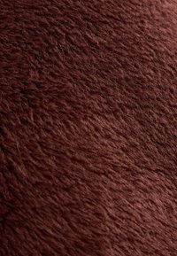 Burgundska umetna krzna tkanina z gosto, teksturirano površino, ki ima mehak in puhast zaključek. Primerna za oblazinjenje ali dekorativne namene.