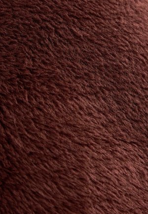 Burgundská umelá kožušina s hustým, textúrovaným povrchom, ktorá má jemný a nadýchaný finiš. Vhodná na čalúnenie alebo dekoratívne použitie.