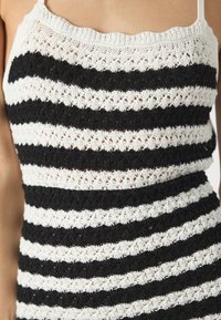 Häkel-Top mit abwechselnd schwarzen und weißen Streifen, einem strukturierten Muster, dünnen Trägern und einer taillierten Passform.