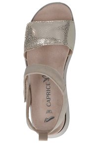 Sandalo beige chiaro con una fascia metallica testurizzata, soletta morbida simile al camoscio, cinturino posteriore regolabile e suola imbottita per il massimo comfort.