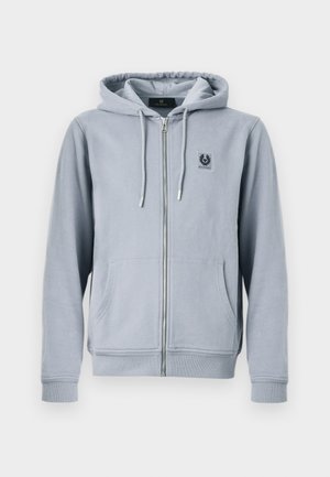 Světlě šedá mikina na zip s kapucí, předními kapsami, šňůrkami na kapuci a malou černou nášivkou s logem na levé straně hrudi.