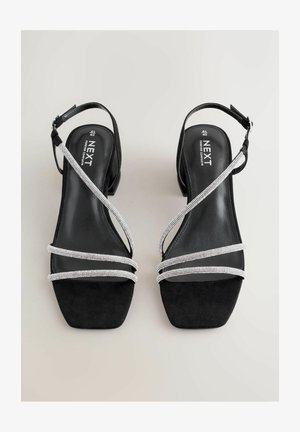 Schwarze Wildledersandalen mit eckiger Zehenpartie, verziert mit drei silbernen Strassriemen und einem Knöchelriemen für sicheren Halt.