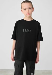 Czarna koszulka z krótkim rękawem wykonana z bawełny, z nadrukiem logo "BAKER BY TED BAKER" z przodu w kontrastowym kolorze. Prosty, kwadratowy krój.