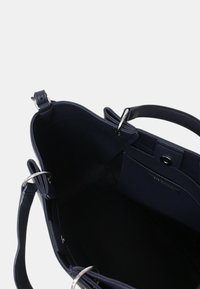 Borsa a mano in pelle blu navale con accessori in argento, apertura superiore e compartimenti interni; texture liscia con un design strutturato.