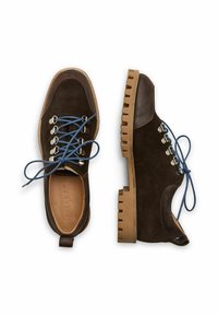 Scarpe in suede marrone con lacci blu, punta arrotondata e suola in gomma spessa e rigata. Presentano occhielli in metallo e un pull tab sul tallone.