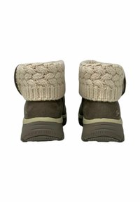 Bruine suède enkellaarsjes met een gebreide beige omslag met een kabelpatroon. Lichtgekleurde rubberen zool met textuur voor grip.