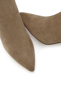 Hnědé semišové lodičky se špičatou špičkou, hladkým povrchem a zúženým designem. Žádná viditelná kovová část nebo vzory.