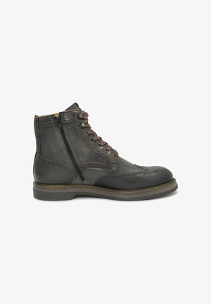 Stivale da ankle in pelle marrone con pannelli in suede, dettagli brogue, chiusura con lacci e zip laterale, punta rotonda e suola piatta in gomma.