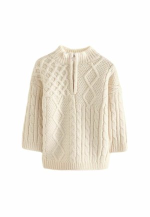 Pull en maille couleur crème avec col montant, demi-fermeture éclair et motifs torsadés texturés variés à l’avant et aux manches.