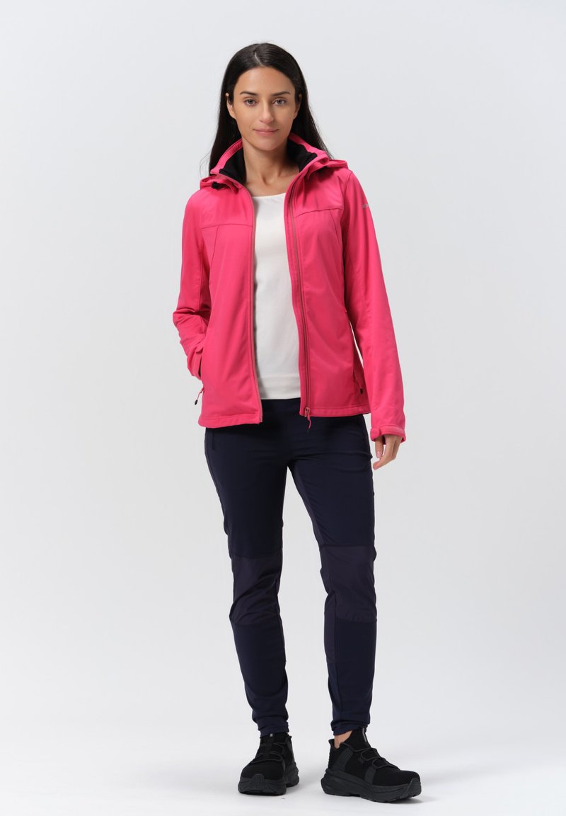Różowa, lekka kurtka zapinana na zamek, z kapturem i kieszeniami po bokach, w połączeniu z ciemnymi spodniami o gładkim i teksturowanym wykończeniu.