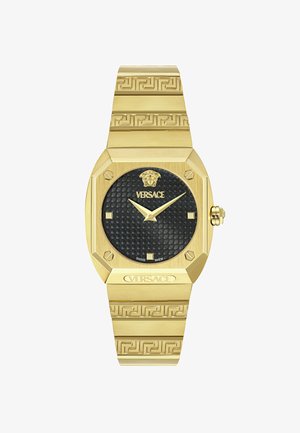 Zlato toniran okrogel ure s črnim teksturiranim številčnico, ki ima grško ključno vzorčenje na zapestnici in logotip Versace na vrhu.