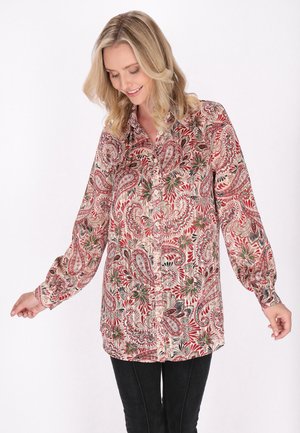 Blusa a maniche lunghe con motivo paisley in rosso, verde e beige. Presenta una chiusura frontale con bottoni e un collo con elastico ai polsini.