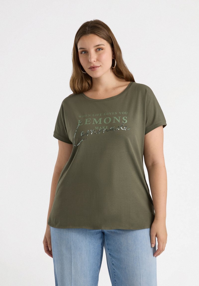 Olivgrön t-shirt i mjukt tyg, med rund halsringning och korta ärmar. Framsidan har text i kontrasterande färger med en skinande detalj.