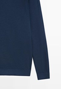 Maglione a maglia blu navy con maniche lunghe, polsini e orlo a coste, caratterizzato da una texture liscia e un design semplice.