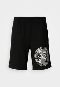 Sorte idrettsshorts med elastisk livbånd og hvitt rundt "Hugo Boxing Academy"-logo som viser to boksere i aksjon på høyre ben.