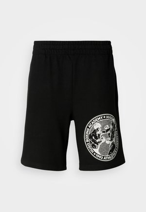 Black athletic shorts with elastic waistband and white circular "Hugo Boxing Academy" logo showing two boxers in action on right leg.