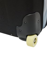 Black wheeled suitcase detail featuring a yellow rubber wheel with a textured surface and silver hardware, mounted on a sturdy black base.