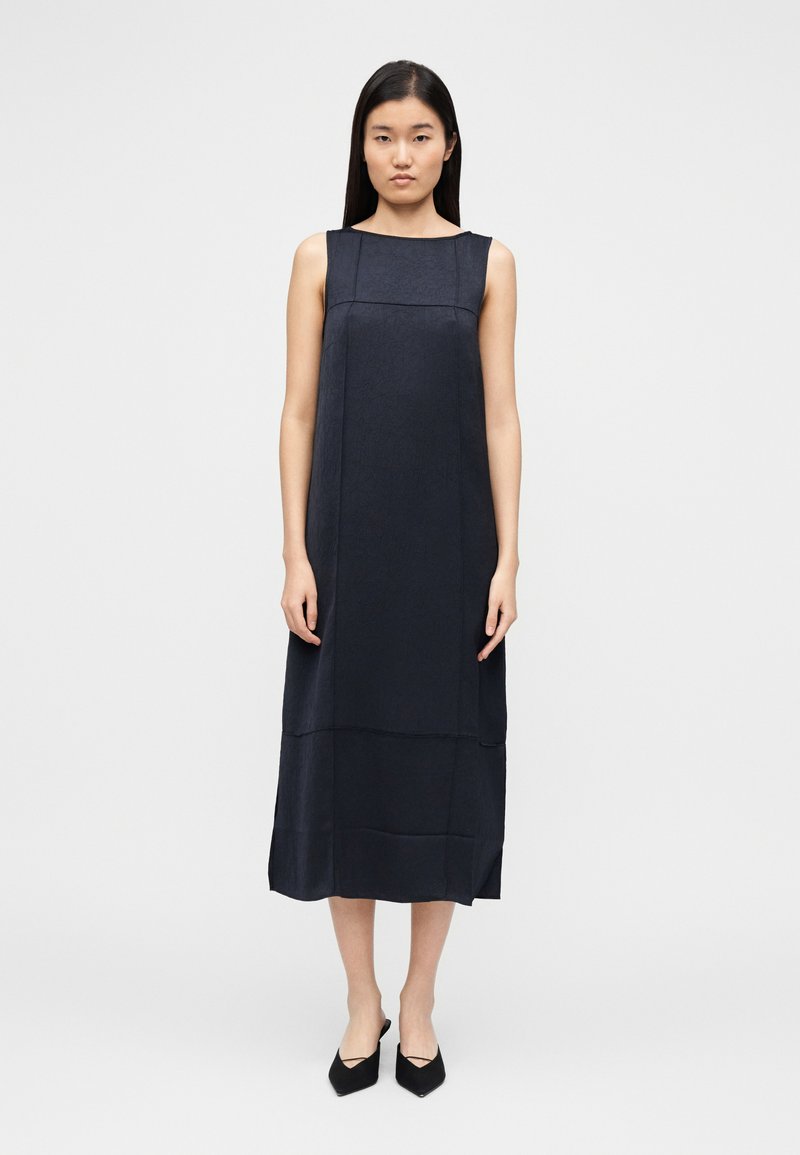 Varrukateta tumesinine kleit sirge lõike ja põlveni ulatuva pikkusega, millel on tekstuuriga kangas ja minimalistlik disain. Ühtlane, nähtavate mustriteta.