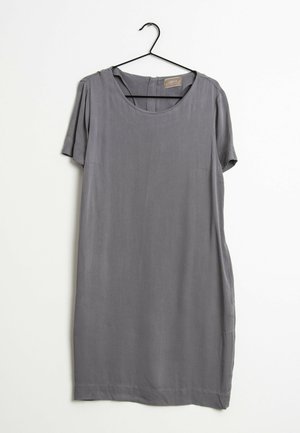 Robe grise à manches courtes avec un col rond suspendue sur un cintre noir sur fond blanc.