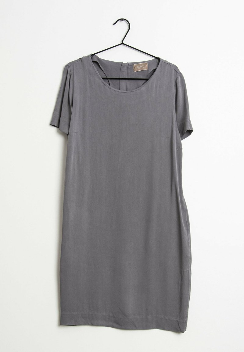 Robe grise à manches courtes avec un col rond suspendue sur un cintre noir sur fond blanc.