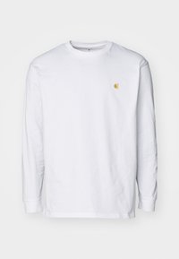 Witte lange mouwen crewneck shirt met klein geel logo op de linkerkant van de borst, gepresenteerd tegen een eenvoudige witte achtergrond.