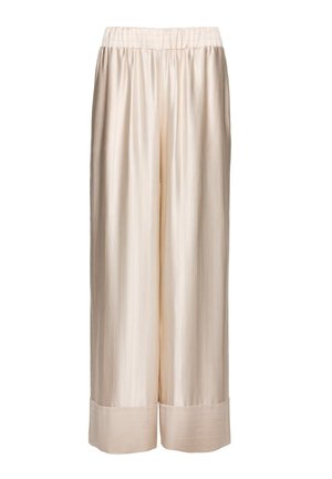 Kremowe spodnie z szerokimi nogawkami wykonane z satyny, z elastycznym pasem i ściągaczami u dołu, charakteryzujące się gładką, błyszczącą fakturą.