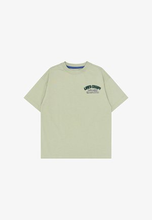 Lysegrøn T-shirt med korte ærmer og rund hals med lille mørkegrøn og hvid tekst på venstre bryst, der lyder "Lad os nyde krummerne."