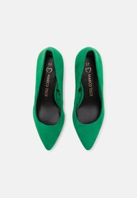 Scarpe alte in suede verde con punte appuntite, texture liscia e rivestimento interno nero. Presentano la scritta dorata del marchio sulla suola. Misura 37.