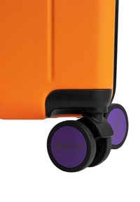 Oranje koffer met een gestructureerde afwerking, voorzien van zwarte en paarse wielen gemarkeerd met "ETERNITIV." Compact, modern ontwerp.