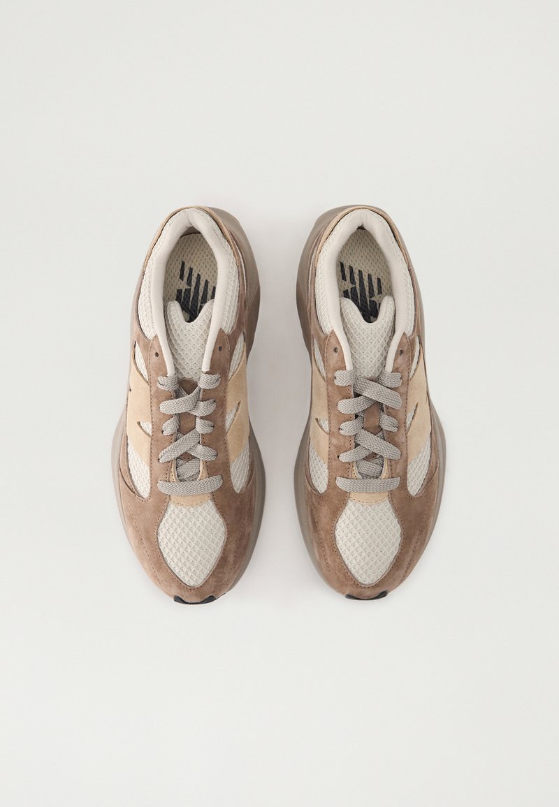 Sneaker marroni e beige con tessuto a rete e dettagli in suede. Presentano una suola testurizzata, punta rotonda e lacci neutri.