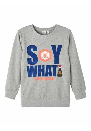 Graues Sweatshirt mit langen Ärmeln, auf der Vorderseite mit dem Text "SOY WHAT", dem Kikkoman-Logo und einer kleinen Grafik einer Sojasaucenflasche.