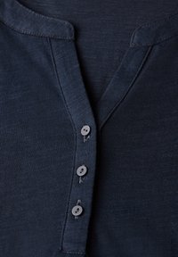 Navyblaue Henley-Shirt mit einer Knopfleiste mit drei Knöpfen, einem runden Kragen und einem strukturierten Strickmaterial.