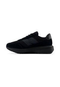 Fekete New Balance sportcipő texturált velúrból és hálóból készült felsőrésszel, vastag párnázott talppal, oldalt és a sarkán logóval, oldalnézetből bemutatva.