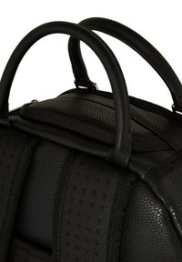 Mochila negra texturizada con asas dobles, soporte trasero acolchado y correas ajustables. Compartimento con cremallera visible en la parte superior.