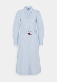 Ljust blå, långärmad skjortklänning med bälte i midjan. Har en krage och rak skärning, tillverkad av ett mjukt tyg.