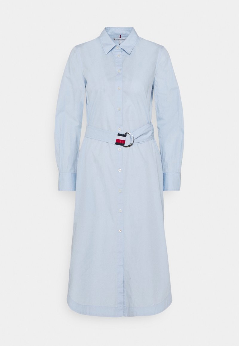 Ljust blå, långärmad skjortklänning med bälte i midjan. Har en krage och rak skärning, tillverkad av ett mjukt tyg.