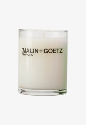 Weiße Kerze in einem klaren Glasbehälter mit der Aufschrift "MALIN+GOETZ new york" auf weißem Hintergrund, Docht sichtbar, aber unbeleuchtet.