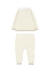 Ensemble tricoté crème comprenant un haut à manches longues avec un col blanc et un détail de bouton, associé à un pantalon ajusté assorti avec des poignets côtelés.