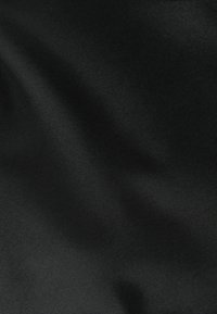 Tela negra con una textura suave, que presenta un ligero brillo. La superficie parece ligeramente arrugada, mostrando su flexibilidad y suavidad.