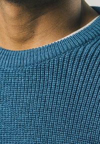 Blauer, gerippter Pullover mit strukturiertem Strickmuster, mit Rundhalsausschnitt und hellfarbiger Innenkragen.
