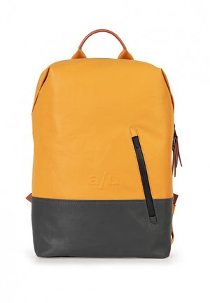 Zaino in pelle giallo con fondo grigio scuro, dotato di una tasca con zip laterale e di un manico superiore in pelle. Design minimalista con logo del marchio.