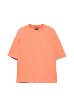 T-shirt oversize corallo a maniche corte con scollo rotondo e piccolo logo bianco sul petto sinistro.