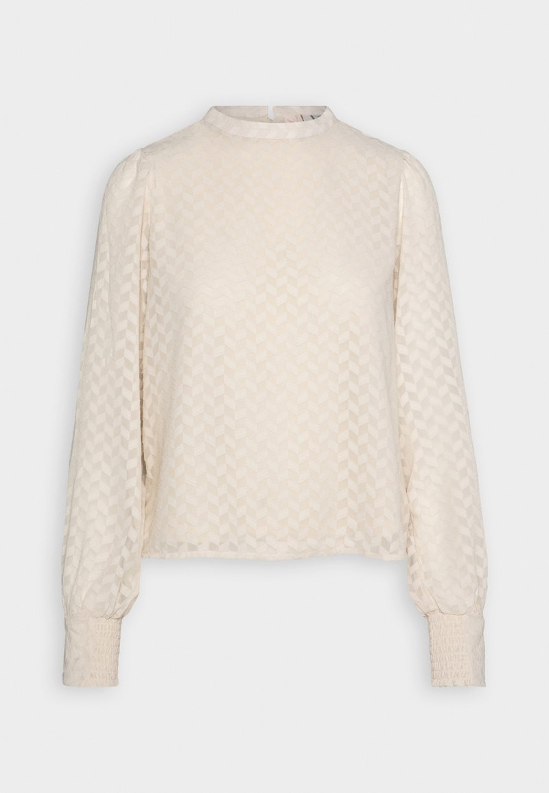 Light beige long-sleeve blouse with a high neck, featuring a textured chevron pattern and smocked cuffs. Made from a soft, lightweight fabric.