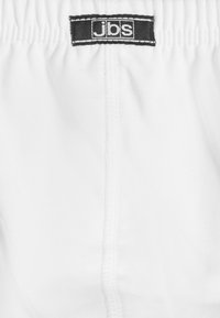 Witte shorts met een elastische tailleband en een zwart etiket met het "jbs" logo. Glad materiaal en eenvoudig ontwerp, geschikt voor casual gebruik.
