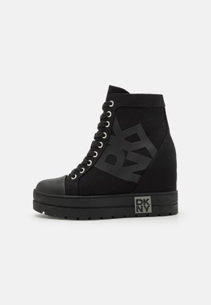 Czarne sneakersy botki na koturnie z sznurowanym przodem, gumowym noskiem, grubą podeszwą i dużym logo DKNY po boku i na podeszwie.