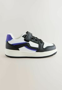 Child’s low-top sneaker with black, white, and purple leather panels, featuring laces and a Velcro strap on a white sole.
