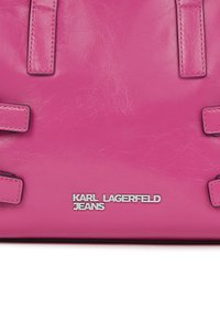 Ροζ δερμάτινη τσάντα χειρός με ασημένιο λογότυπο "Karl Lagerfeld Jeans" και ορατές ραμμένες λουρίδες.